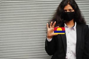 asiatico donna a formale indossare e nero proteggere viso maschera hold palmyra atollo bandiera a mano contro grigio sfondo. coronavirus a nazione concetto. foto