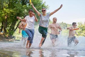 gruppo di contento amici avendo divertimento su fiume foto