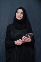 giovane moderno musulmano attività commerciale donna utilizzando tavoletta computer foto