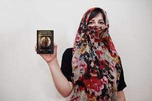giovane arabo musulmano donna nel hijab Abiti hold repubblica di tagikistan passaporto su bianca parete sfondo, studio ritratto. foto