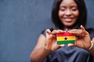 africano donna hold piccolo Ghana bandiera nel mani. foto