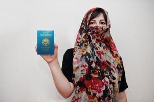 giovane arabo musulmano donna nel hijab Abiti hold kirghiso repubblica passaporto su bianca parete sfondo, studio ritratto. foto