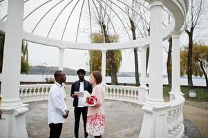 nozze Fidanzamento cerimonia con pastore. contento multietnico coppia nel amore storia. relazioni di africano uomo e bianca europeo donna. foto