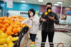 asiatico coppia indossare nel protettivo viso maschera shopping insieme nel supermercato durante pandemia. la scelta diverso frutta. foto