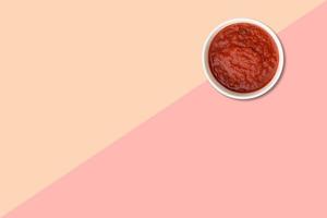 vicino su Visualizza rosso pomodori ketchup isolato su rosa sfondo. foto