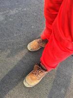 salutare sicurezza e ambientale ufficiali chi indossare rosso pantaloni uniformi e Marrone sicurezza scarpe. foto