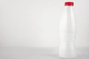 bianca plastica bottiglia per latte su un' bianca sfondo. copia spazio foto