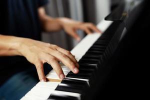 primo piano della mano persone uomo musicista che suona la tastiera del pianoforte con i tasti di messa a fuoco selettiva. può essere utilizzato come sfondo. foto