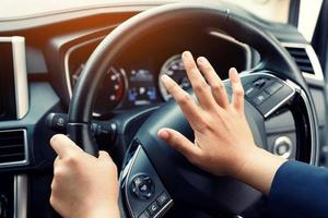 uomo che spinge il clacson mentre guida seduto su un'auto della pressa del volante, suonando il clacson per avvisare le altre persone nel concetto di traffico. foto