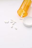 ovale pillole e arancia pillola bottiglie erano diffusione su su il bianca da tavolo. foto