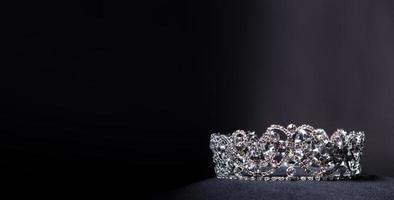 diamante argento corona per Perdere spettacolo bellezza concorso, cristallo tiara gioielleria decorato gemme pietra e astratto buio sfondo su nero velluto tessuto stoffa, macro fotografia copia spazio per testo logo foto