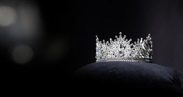 diamante argento corona per Perdere spettacolo bellezza concorso, cristallo tiara gioielleria decorato gemme pietra e astratto buio sfondo su nero velluto tessuto stoffa, macro fotografia copia spazio per testo logo foto