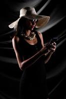 silhouette di giovane donna hold oro bitcoin criptovaluta commercio in linea al di sopra di drappo tenda nero sfondo, bellissimo femmina pose metà corpo come lusso perla trascurare cappello sole bicchieri foto