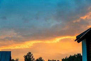 case e alberi a tramonto. tramonto nel il campagna. sera drammatico cielo e a casa. foto