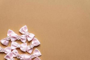 rosa raso fiocchi con perla cuori modello su beige sfondo. festivo concetto per st San Valentino giorno foto