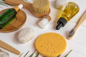 naturale terme cosmetico prodotti, composizione con bottiglie di essenziale oli, mare sale, spugne, spazzole e massaggio utensili su bianca sfondo. zero rifiuto concetto foto