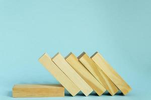 di legno blocchi su blu sfondo. domino effetto nel attività commerciale concetto. foto