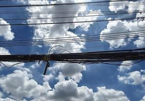 disordinato elettricità fili su il palo, dritto linea di cavi e fili su un elettrico polo nel Tailandia, cielo e nuvole sfondo foto