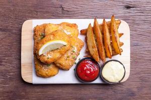 fish and chips con spicchio di patate foto