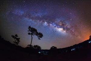 silhouette di albero e via lattea al parco nazionale di phu hin rong kla, phitsanulok thailandia. fotografia a lunga esposizione. foto