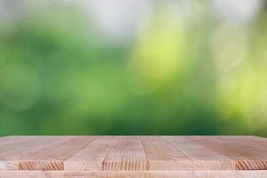 piano del tavolo in legno su sfondo verde bokeh - può essere utilizzato per il montaggio o visualizzare i tuoi prodotti foto