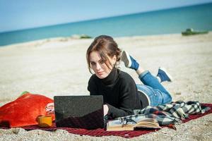 giovane donna godendo sua Lavorando su il spiaggia foto