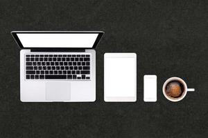 tablet laptop smartphone e caffè su sfondo nero tavolo con spazio di testo e spazio di copia foto