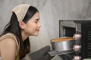 la giovane bella donna sta cuocendo nella sua attività di cucina, panetteria e caffetteria foto