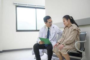 asiatico medico è Lavorando nel ospedale , parlando con tristezza donna , medico Salute cura concetto foto
