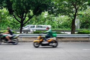 Corriere o consegna uomo su motocicletta in movimento veloce, sfocato movimento. Corriere trasporta su ordini per consegna nel urbano la zona. foto