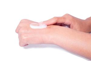 avvicinamento donna l'applicazione protettivo crema su mani. foto