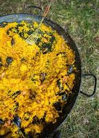 paella tradizionale spagnolo cibo. paella preparato su un' grande padella su il strada su fuoco foto