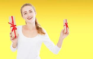 ritratto di un' contento sorridente donna, ragazza nel bianca camicia Tenere presente scatole isolato su giallo sfondo, vacanze sfondo foto