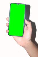 maschio mano Tenere un' mobile Telefono su un' bianca sfondo adatto per un' verde schermo, un' mano Tenere un' verde schermo mobile Telefono foto