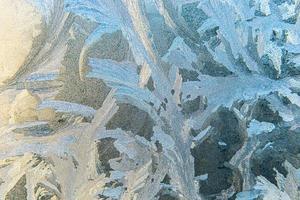 finestra invernale congelata con struttura a motivo ghiaccio brillante. simbolo di meraviglia di natale, sfondo astratto. temperatura bassa estrema del nord, neve ghiacciata naturale su vetro gelido, clima invernale fresco all'aperto. foto
