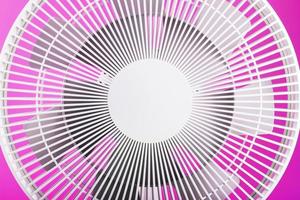 elettrico fan nel bianca con un' moderno design per raffreddamento il camera su un' rosa sfondo. foto