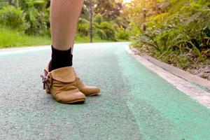 donne indossare Marrone scarpe su verde asfalto strada nel giardino foto