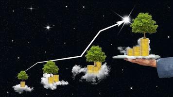 uomo d'affari Tenere un' tavoletta con emorroidi di monete e albero e nube su nero cielo sfondo, affari crescita e grafico di indicatori concetto foto