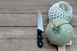 melone e coltello su taglio tavola foto