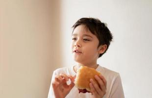 salutare ragazzo mangiare fatti in casa Bacon panini con misto la verdura, isolato ritratto contento giovane ragazzo avendo prima colazione a casa prima partire per scuola foto