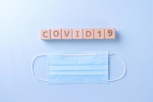 covid-19 parola di legno cubo con maschera, medico attrezzatura, mondo malattia pandemia infezione e prevenzione concetto, superiore Visualizza, piatto posizione, alto design foto