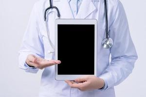 medico con stetoscopio nel bianca cappotto Tenere tavoletta, mostrando medico informazione, diagnosi, isolato su bianca sfondo, vicino su, ritagliata Visualizza. foto