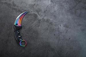 un' pugnale con un' acciaio lama con un' pendenza colore su un' nero sfondo. foto