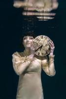 spaventoso donna con orologio nel sua mani nel nero velo subacqueo foto