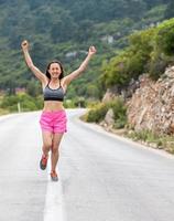 il corridore finì e alzò le mani, una donna che faceva jogging serale foto