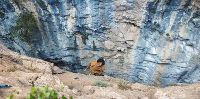 forte uomo arrampicata un' roccia. foto