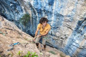 forte uomo arrampicata un' roccia. foto