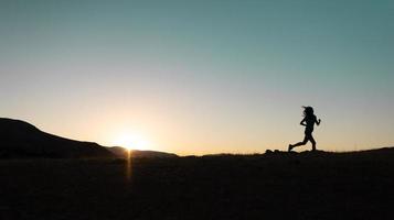 ragazza corre a tramonto nel il montagne. foto