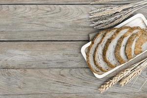 pane pagnotta e Grano orecchie e sacco su di legno sfondo. foto
