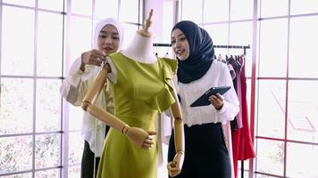bellissimo musulmano donne Lavorando insieme a il capi di abbigliamento ufficio. foto